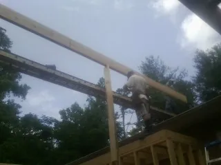 Carpenter setting a ridge beam over a new addition frame — Ice Dam Removal by Roofing Brothers in Voluntown