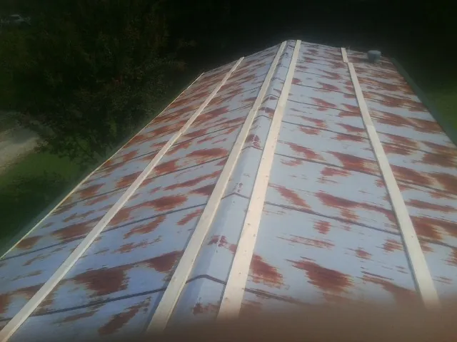 Rusted metal roof panels with new wood purlins before replacement — Storm Damage Roof Repair in Voluntown by Roofing Brothers