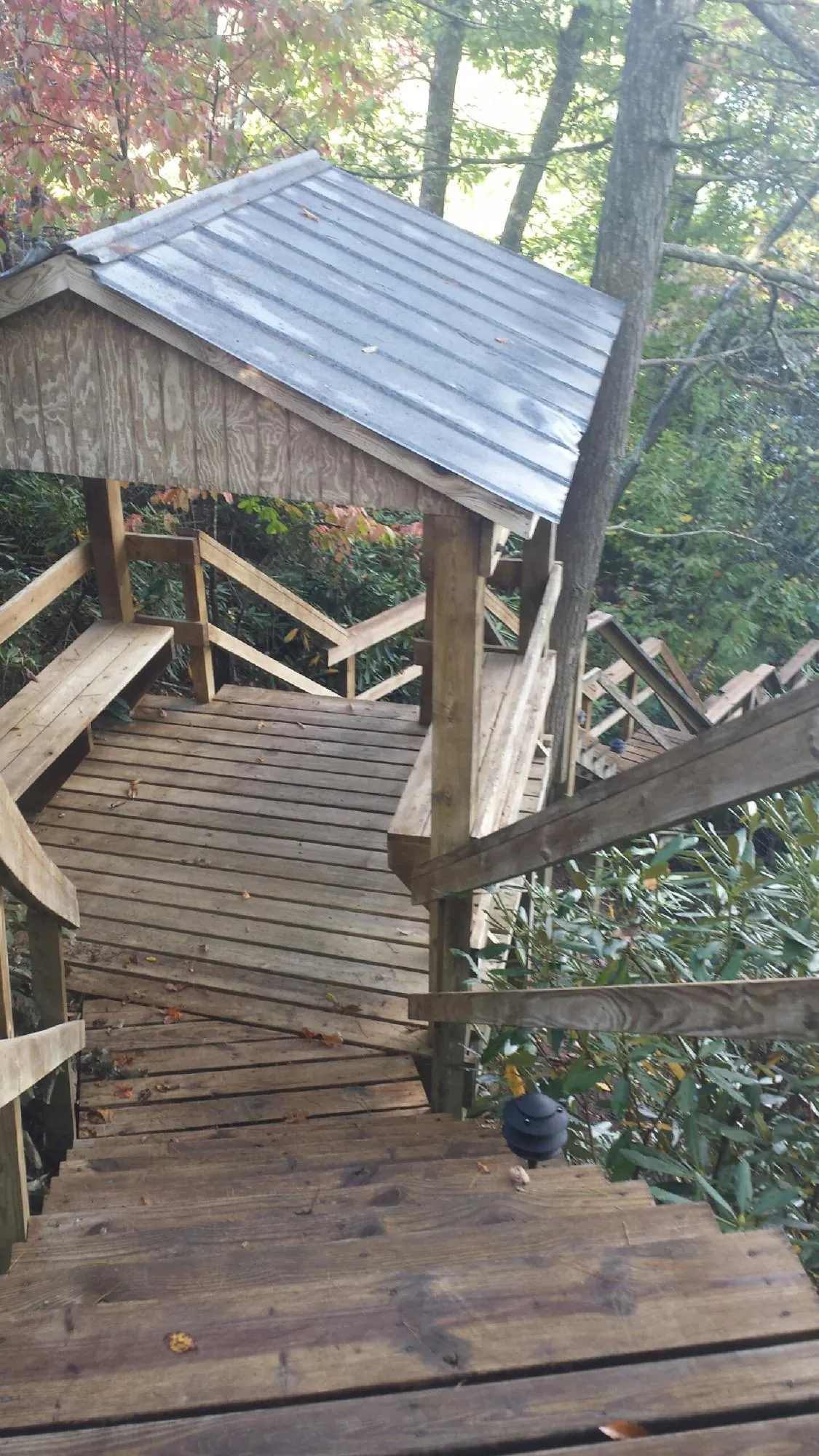 Metal roofed shelter over wooden steps on a wooded walkway — Skylight Repair & Installation work by our crew in Voluntown