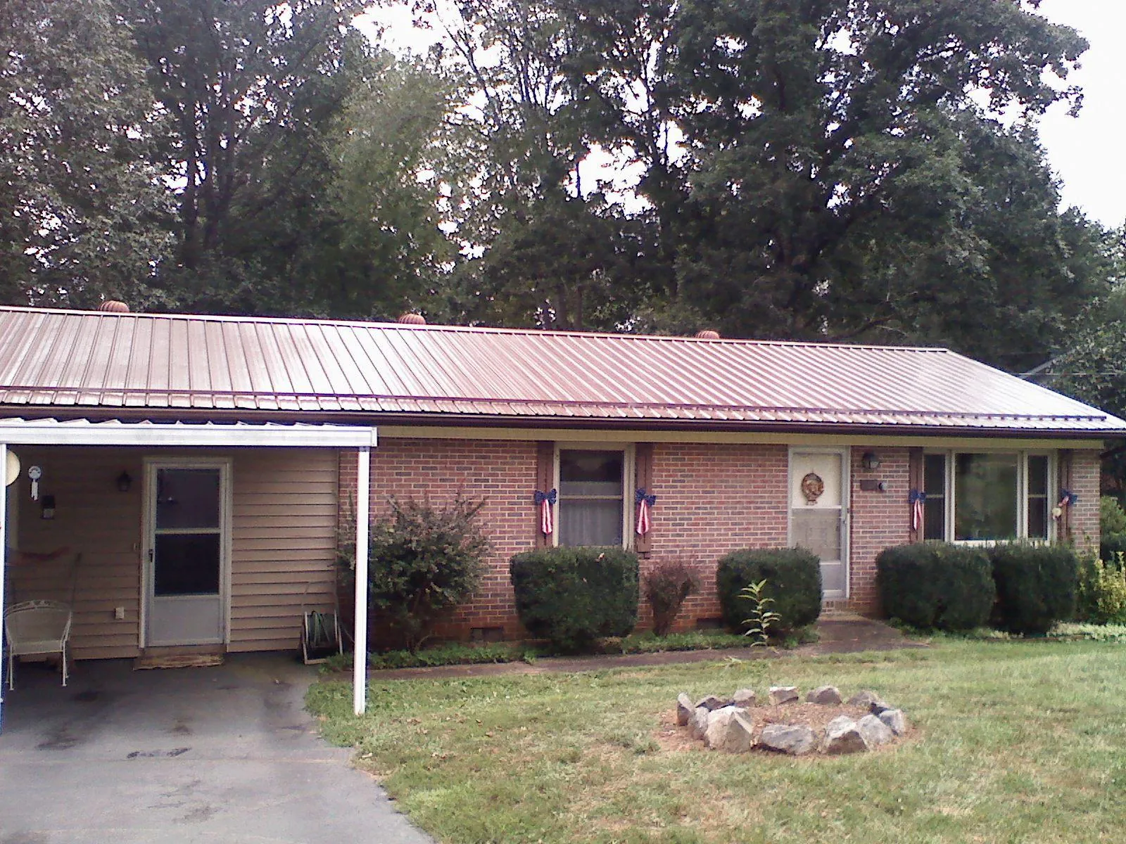Bronze metal roof and carport on a brick ranch home — Roof Repair work by our crew in Voluntown